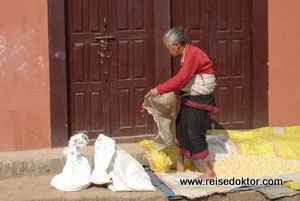 Nepal: Frau beim Maistrocknen